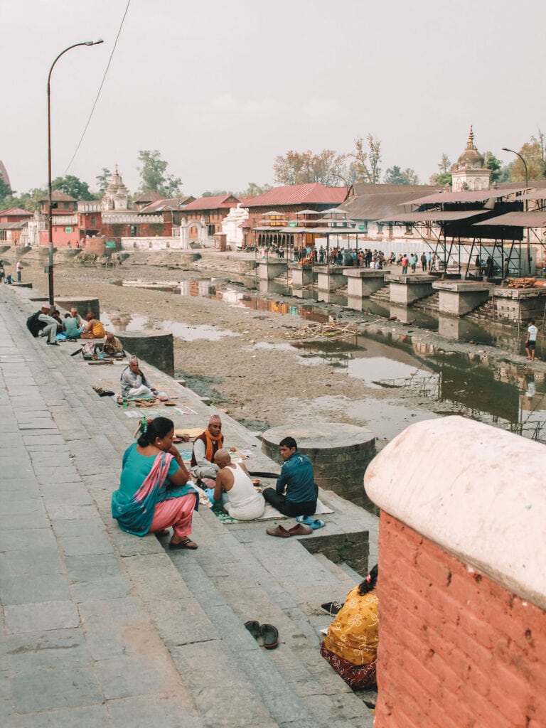 locals sitting on the river banks at Pashupatinath Temple in Kathmandu. day 3 kathmandu itinerary