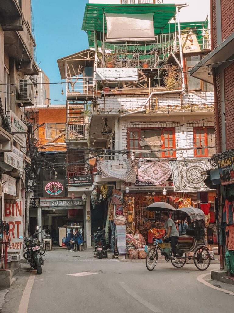 streets of Thamel and an empty rickshaw riding on the road. day 1 of Kathmandu itinerary