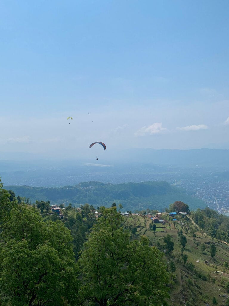 View of the landscape surrounding Pokhara, Nepal. With two paragliders flying through the sky