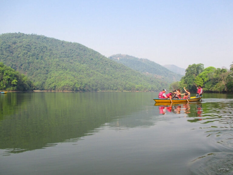 locals and foreigners on a yellow row boat in Pokhara. Things to do in Pokhara - hire row boat on Phewa Lake