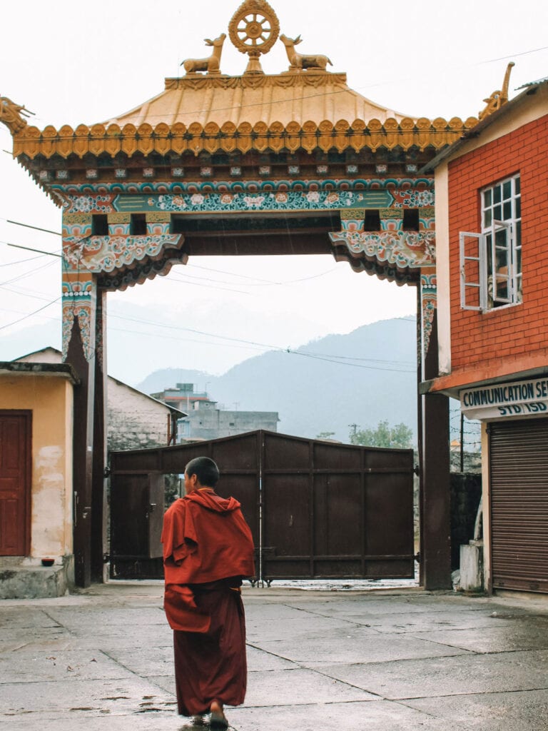Monk walking towards the main gate at a monastery near Pokhara in Nepal