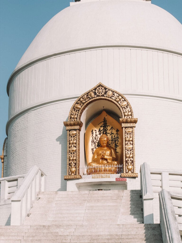 the main stairs leading up to the World Peace Pagoda in Pokhara, Nepal. And, one of the gold Buddhas on display