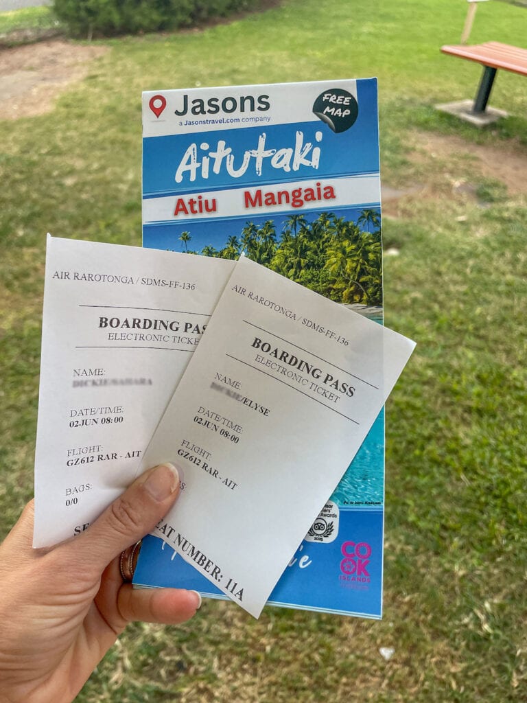 Hand holding airport boarding passes for Air Rarotonga to Aitutaki.
