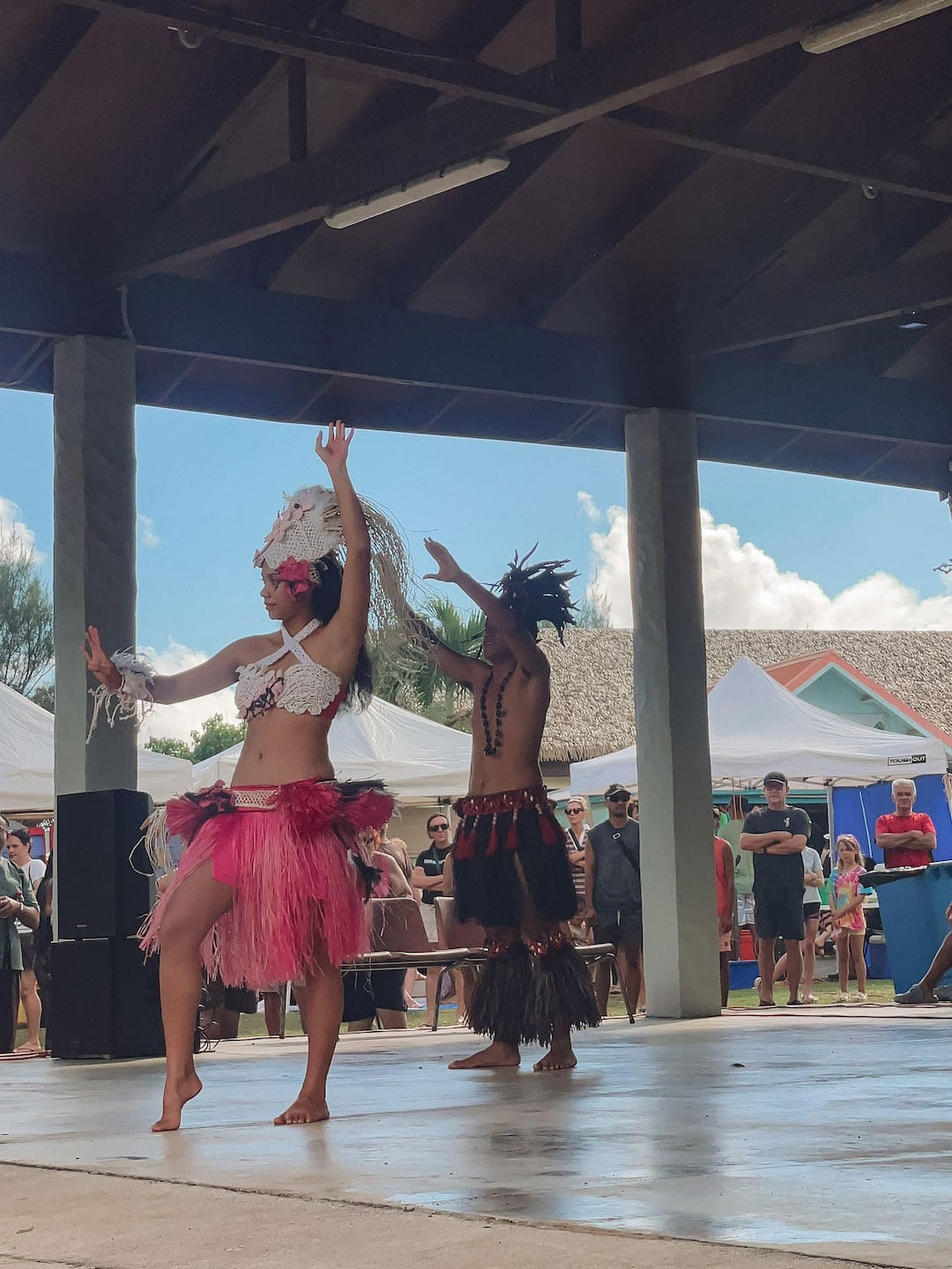 Tropical dancers performing under a pavilion Punanga Nui Market